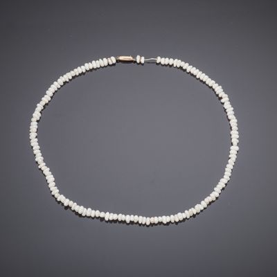 un collier de perles blanches avec un fermoir en or