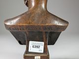 an old bronze bust of a woman on a pedestal with a tag on it