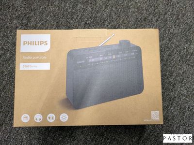 La boîte de la radio Philips est ouverte sur le tapis.