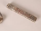 a silver pen with a chain around it on a white surface