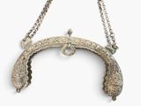 an old silver purse with a chain hanging from it ' s side