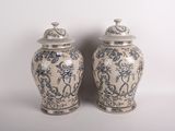 pair of blue and white vases sitting on a white surface