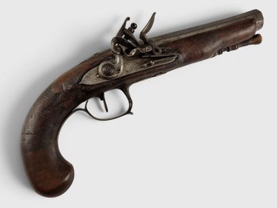 un gros plan d'un pistolet sur une surface blanche avec un fond blanc