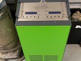 une machine posée par terre à côté d'une pile de fûts