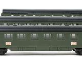 three green train cars sitting next to each other on a white surface