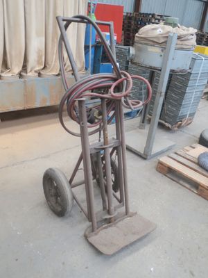 un diable muni d'un tuyau dans un entrepôt