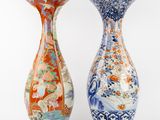 pair of chinese vases with floral designs on them against a white background