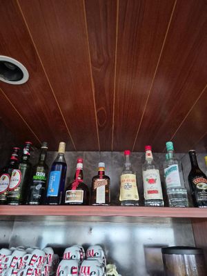 de nombreuses bouteilles et canettes d'alcool sur une étagère