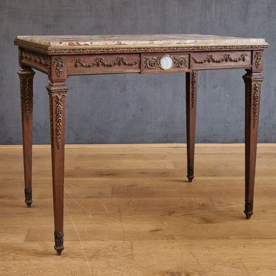 a small table with a marble top on a wooden floor
