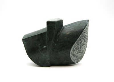 a black stone sculpture of a bird on a white surface