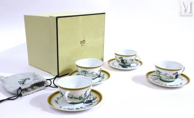 quatre tasses et soucoupes posées devant une boîte