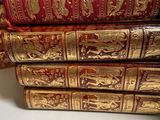 several red and gold books stacked on top of each other