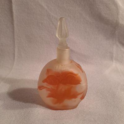 une petite bouteille en verre ornée d'un motif rouge et blanc