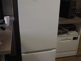 a white refrigerator with a microwave on top of it