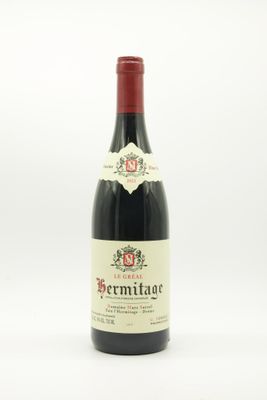 a bottle of red wine sitting on top of a white table