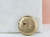 a close up of a gold ring on a white marble block