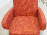 an orange and orange chair with bamboo print on it in front of a mirror