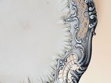 a silver plate with a decorative design on it
