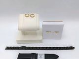 a close up of a watch on a white surface next to a box