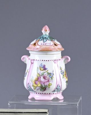 a pink and white vase with a lid on a clear stand