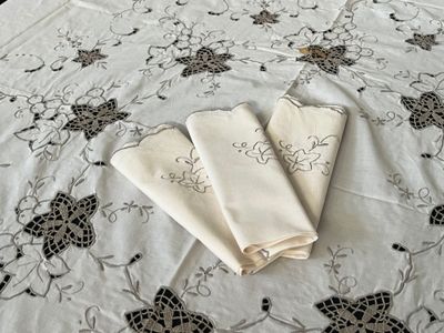 two folded napkins on a bed with a floral design
