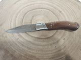 a knife that is sitting on top of a piece of wood