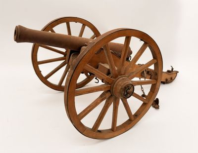 un vieux canon en bois posé sur une roue en bois