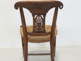 a wooden chair that has a wicker seat on it