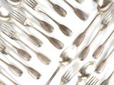 de nombreuses cuillères et fourchettes disposées ensemble sur une surface blanche