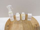 three bottles of soap and a bottle of lotion sitting on a wooden tray