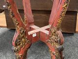 une paire de chaises en bois peintes en rouge et or, posées sur un sol recouvert de moquette