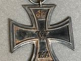 an old iron cross with a ribbon and a medal on a table