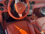 l'intérieur d'une voiture de sport rouge équipée de sièges en cuir et de commandes au volant