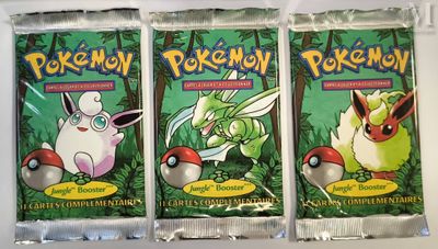 three packs of pokemon trading cards sitting on top of a table