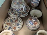 a cardboard box with many different types of pottery in it