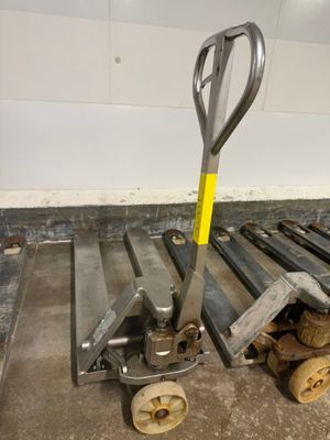 a fork and a pallet on the floor next to a pile of wood