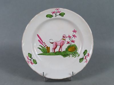 une assiette blanche sur laquelle sont représentés un flamant rose et une grenouille