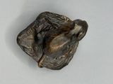 une petite statue représentant un oiseau perché sur un morceau de bois
