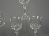 four wine glasses and a decanter on a grey background