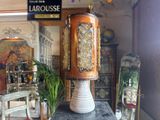 a tall vase sitting on top of a table in front of a mirror