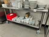 many plates and cups on a metal shelf in a kitchen