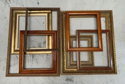 three different sized wooden picture frames on a white wall