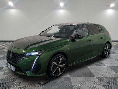 the green car is parked on a checkered floor in a garage