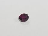 a close up of a purple gemstone on a white surface