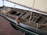 a model of a boat with a sail on a wooden table