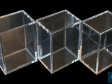 three clear boxes sitting next to each other on a black background
