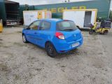 a small blue car parked in front of a trailer