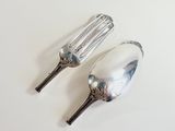 two silver spoons and a fork on a white surface