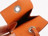 a person holding an orange wallet with a metal ring