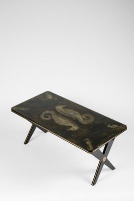 une photo d'une table basse noire et dorée ornée d'un motif représentant un dragon